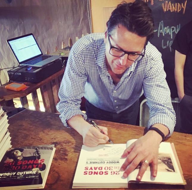 Greg Vandy signs his book, 26 Songs in 30 Days